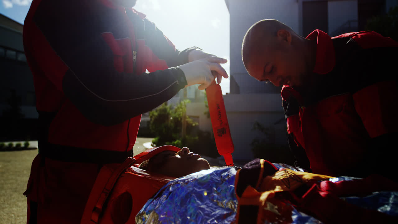 負傷した女の子がベルトでストレッチャーに縛られている