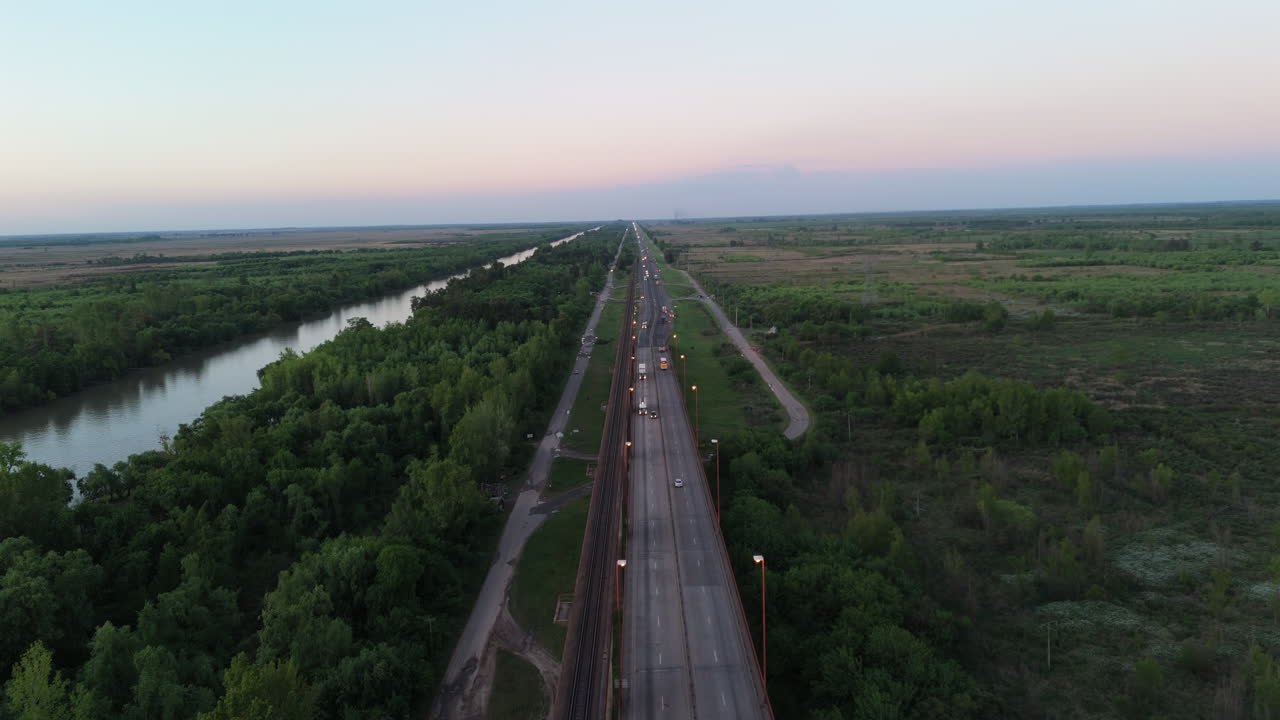 Aerial view of cars driving on Bartolome Mitre Bridge over Parana River Delta at sunset, connecting the cities of Campana and Zarate, Buenos Aires, Argentina