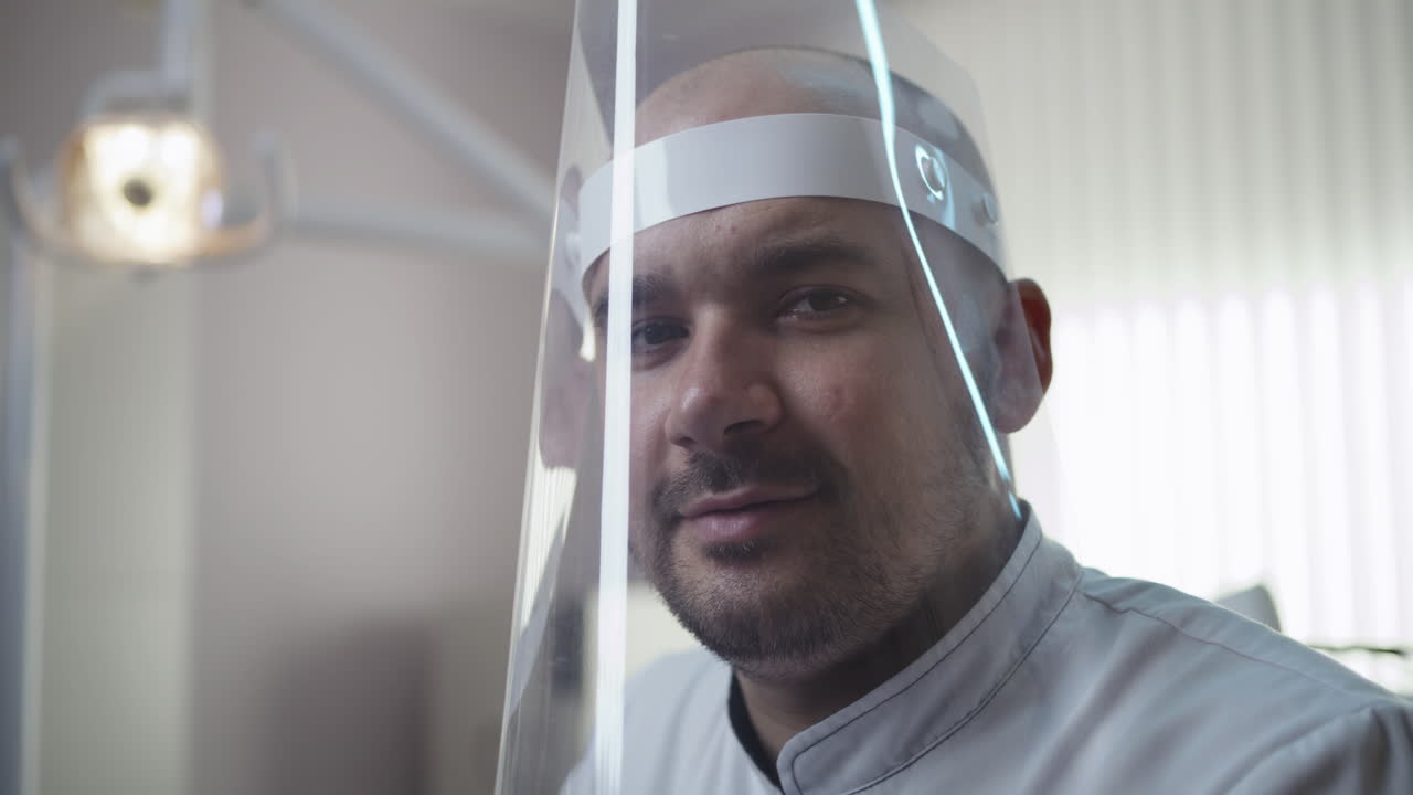 A medical professional wearing a face shield in a clinic