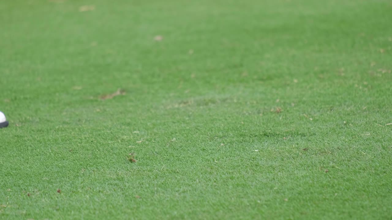Slow motion close up professional golf player swinging golf club on the green. Golfer taking shot on the golf course.