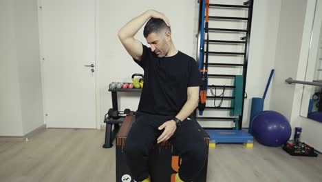 wide shot of a man stretching his neck muscles before a workout