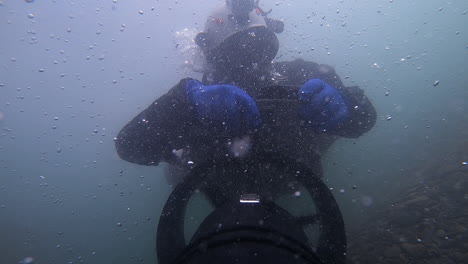 selfie: buzo técnico detrás del scooter en el agua turbulenta del río