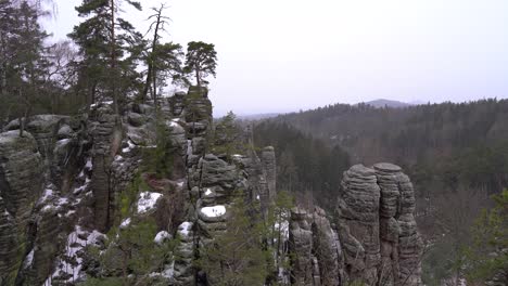 Panorama-De-Una-Formación-Rocosa-De-Arenisca-En-Rocas-Prachov,-Paraíso-Bohemio,-En-Invierno-Con-Castillo-Trosky-En-El-Horizonte,-Camión-A-La-Derecha