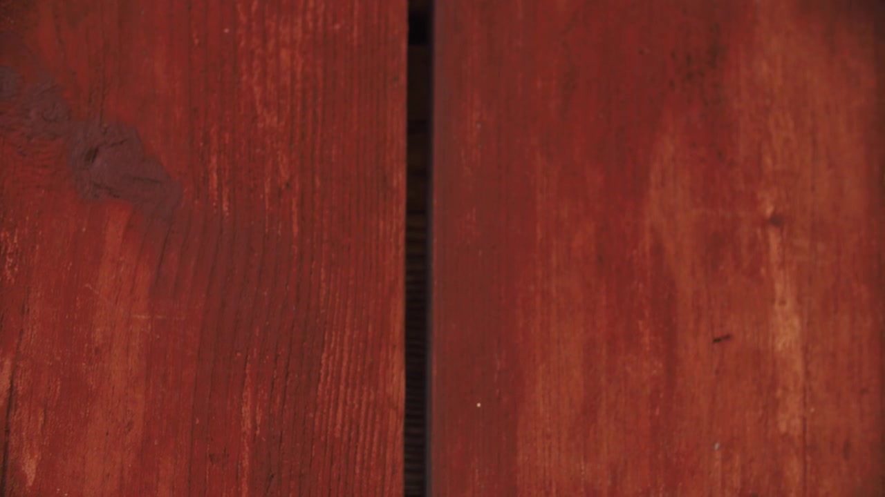 Primer plano de llaves siendo retiradas de una superficie de madera roja