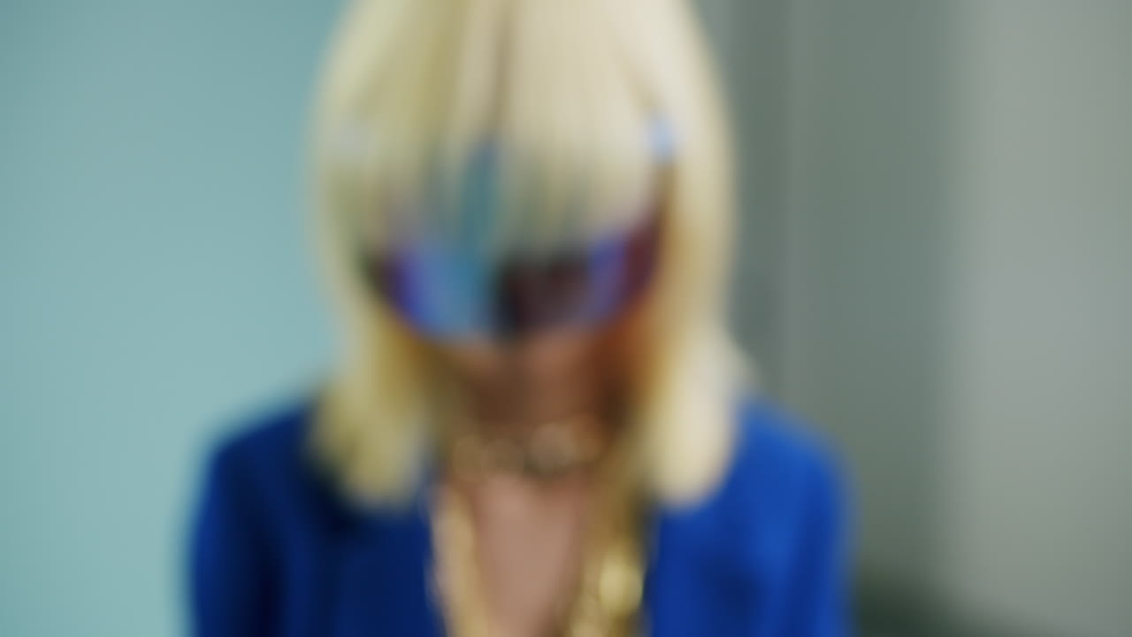 Blonde person in blue clothing wearing a reflective visor creating a modern and futuristic look stunning visuals dynamic movement captivating scenes smooth motion
