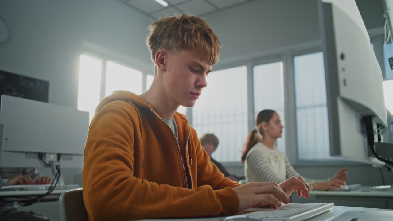 Young Man Looks at Camera While Learning Programming and Design