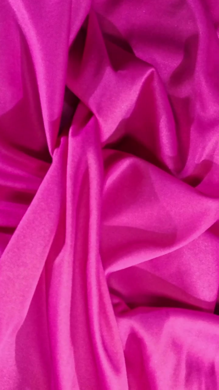 Trama di raso rosa vibrante che si muove in morbide pieghe
