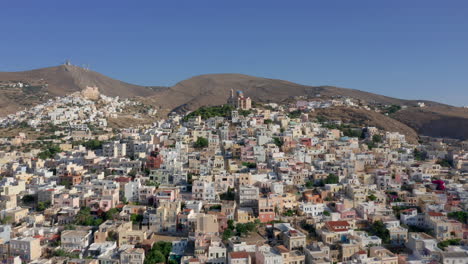 Aerial:-Slow-panning-drone-shot-of-Ermoupoli-city-in-Syros-island,-Greece-during-sunrise