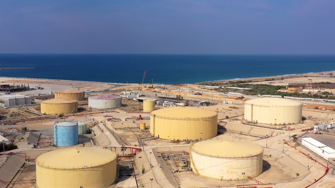 Aerial view of a large industrial storage tank facility near the ocean