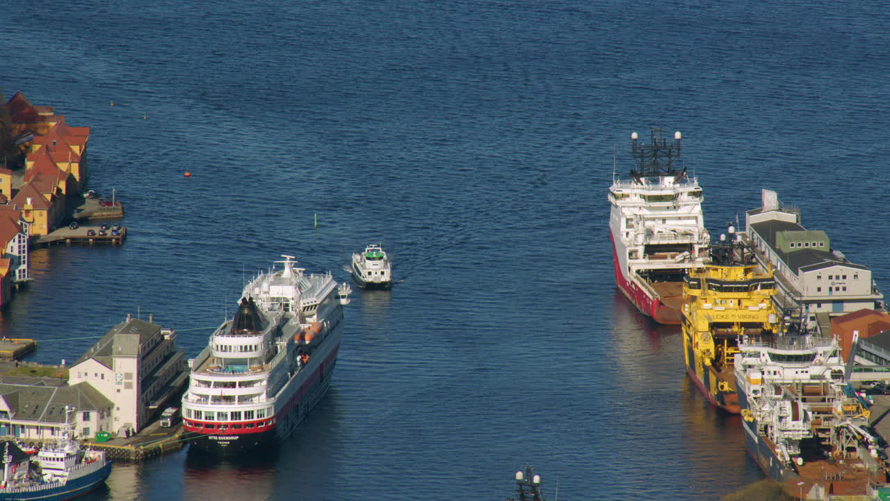 shot of a small boat entering the harbour area in Bergen with cruise ship and commercial shipping. Filmed from Fløyen Panorama