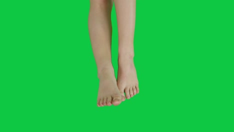녹색 스크린 앞에 긴장하고 매력적인 여성 발