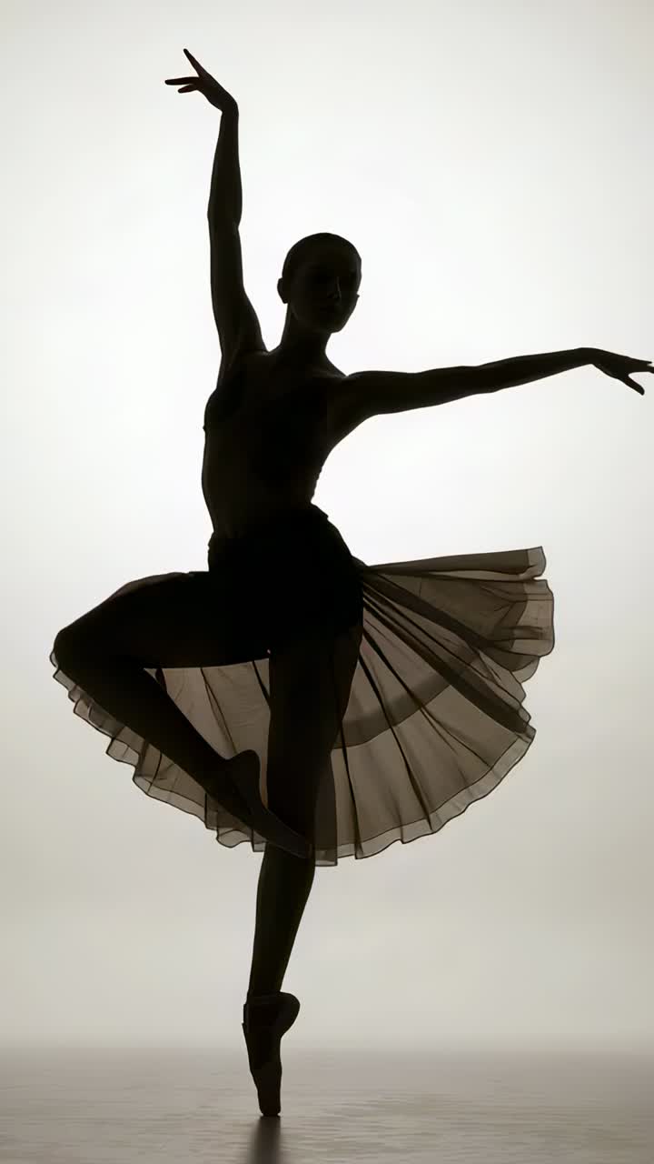 Vertical video: Starting en pointe, dancer turning on studio floor wearing leotard and pointe shoes