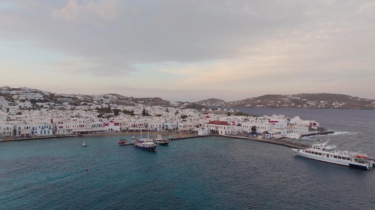 Paralia Choras Mikonou, ön Mykonos med vita byggnader och lugnt hav under mjukt kvällsljus, Kykladerna, Grekland.