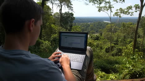 man working on laptop in the forest
