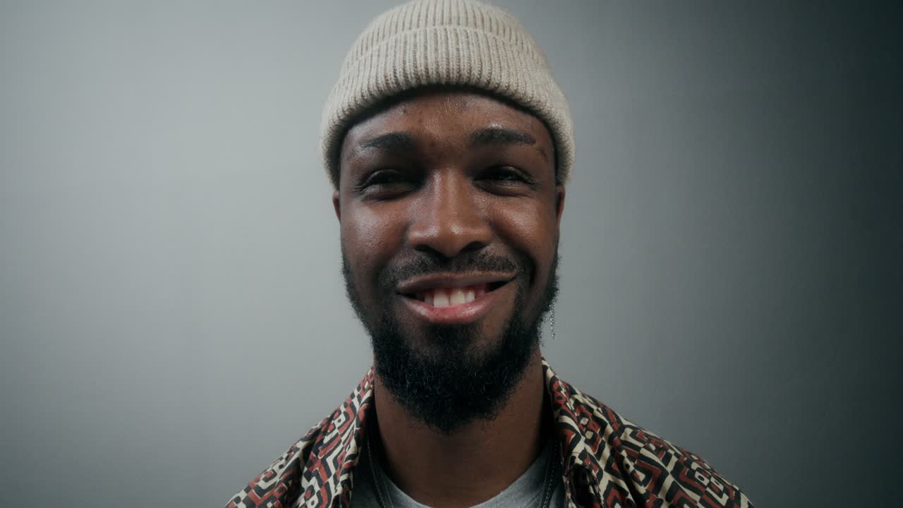 hombre sonriente con sombrero de invierno y camisa étnica