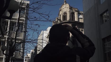 silhouette of woman taking pictures of old building in montevideo