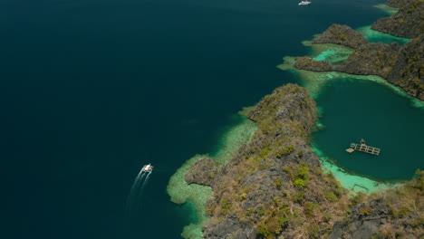 toma aérea siguiendo un bote estabilizador cerca de una isla tropical desierta de el nido, palawan, filipinas