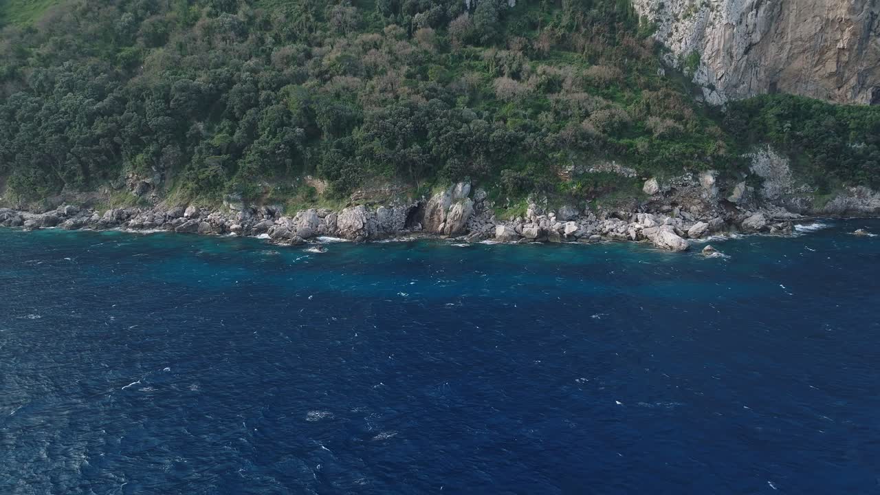 costa de capri, italia con exuberante vegetación y acantilados rocosos sobre el mar azul, la luz del día