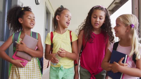 video of happy diverse girls walking at school corridor and talking
