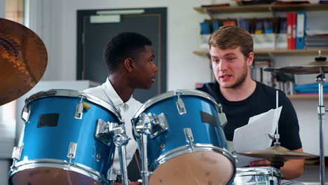 Male-Pupil-With-Teacher-Playing-Drums-In-Music-Lesson