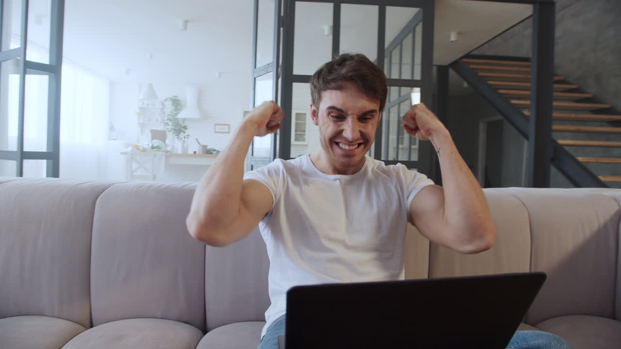 freelancer alegre sonriendo cerca de la computadora en una casa moderna en cámara lenta.