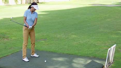 Young-female-golfer-preparing-to-tee-off