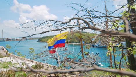 Bandera-Colombiana-Ondeando-En-El-Viento-De-Una-Goleta-Atracada-En-Un-Paraíso-Tropical