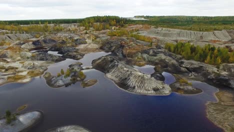 aerial view of an abandoned quarry with lakes and forests