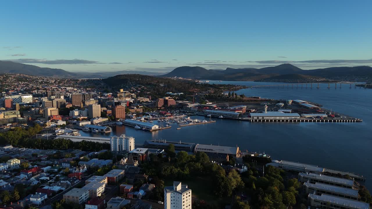 Harbor of Hobart city with mountains in background in Tasmania, orbital drone shot