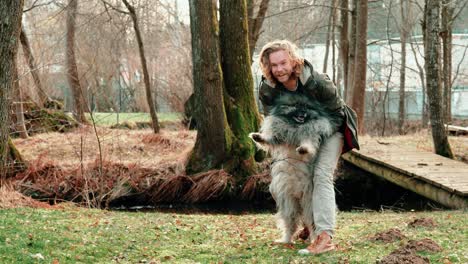 Ein-Flauschiger-Wolsspitz-Wird-Von-Seinem-Herrchen-An-Den-Beinen-Gepackt-Und-Hochgehoben