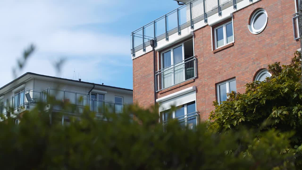 전경에 식물이 있는 아파트 건물의 매우 느린 추적 샷