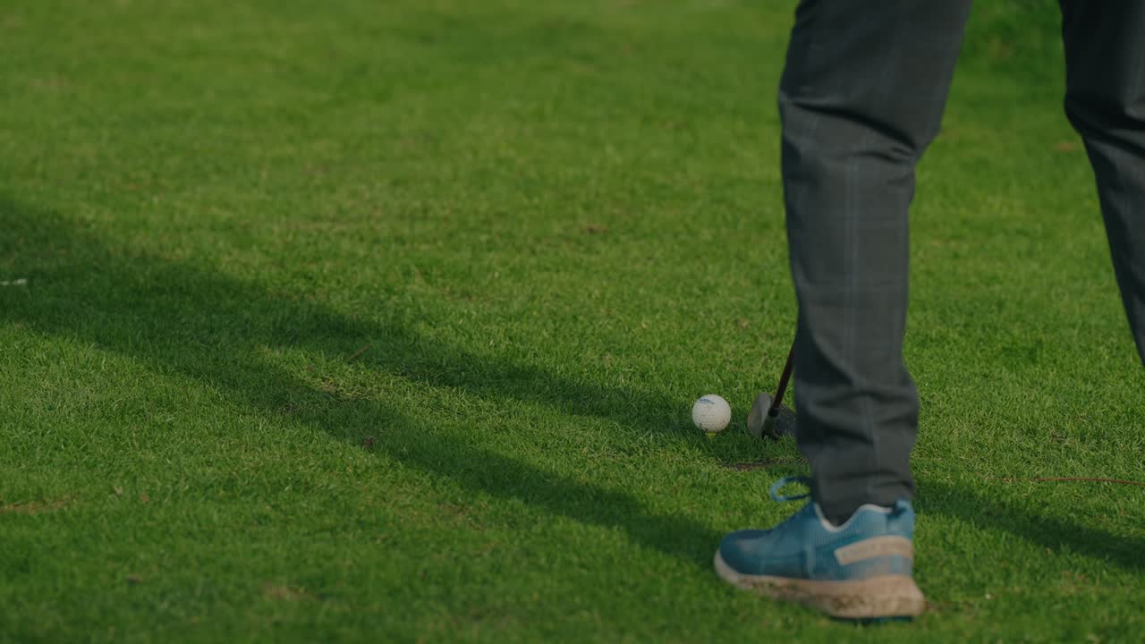Golfer putting ball on grass field during practice