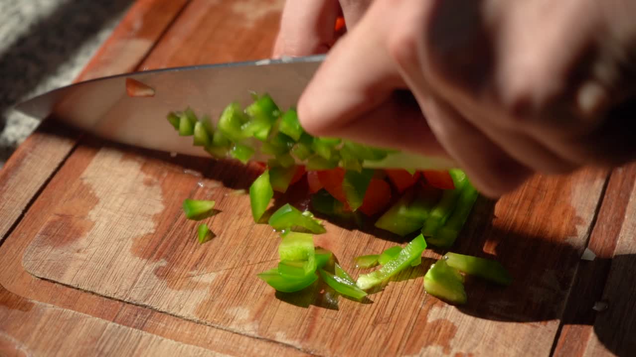 Chopping Red And Green Bell Peppers In Dice On Chopping Board. - close up