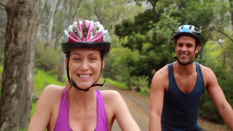 pareja en bicicleta a través de un bosque