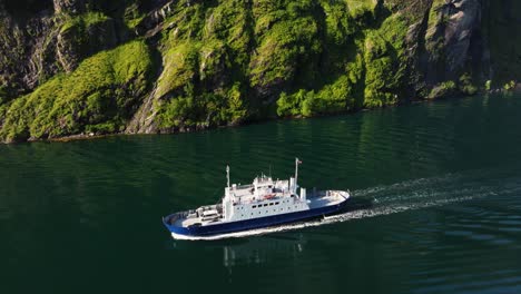 aerial tracking shot of geiranger ferry boat with cars in norwegian fjord