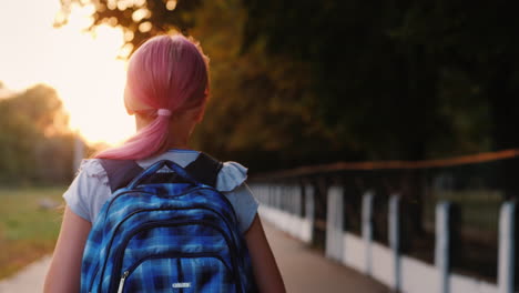 girl with school bag goes to school in the morning back to school