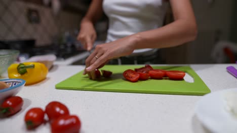 mujer cortando tomates en la cocina