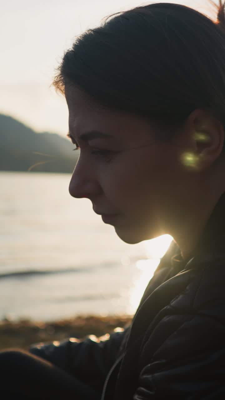 mujer triste sentada en la orilla del río al atardecer. la mujer siente una profunda tristeza preocupada por la soledad. calma naturaleza atmósfera para liberar emociones negativas