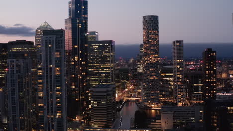 Rückwärts-Zeigen-Von-Wolkenkratzern-In-Canary-Wharf-Business-Center-Gegen-Twilight-Sky.-Beleuchtete-Fenster-Nach-Sonnenuntergang.-London,-Vereinigtes-Königreich