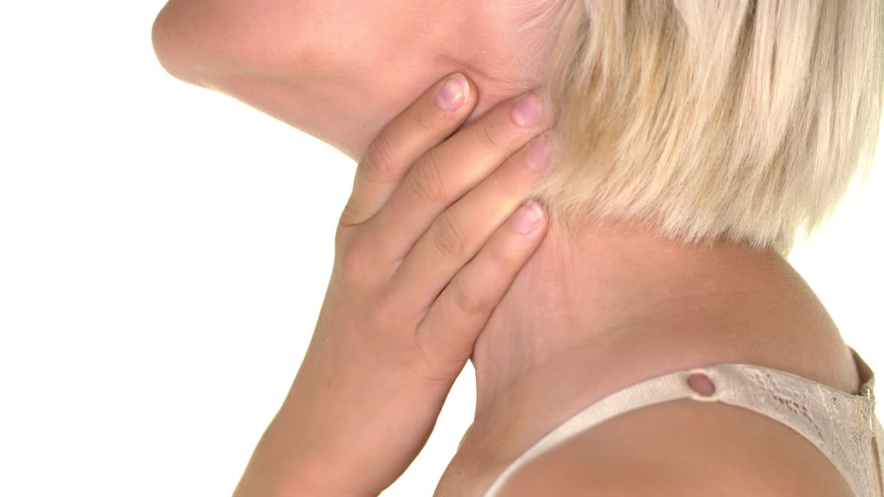Close-up on the neck of a young woman suffering from sore throat and massaging with her hands