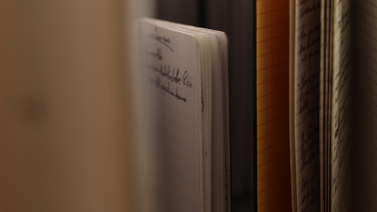 Close-up of a Notebook and Stacked Papers