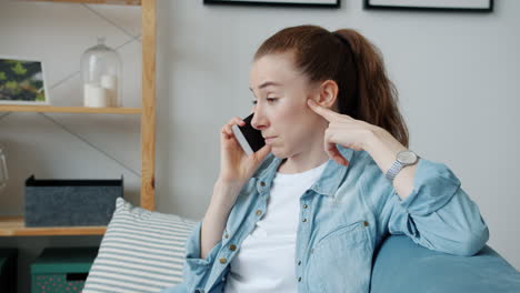 woman having a phone conversation on a couch