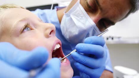 dentista examinando a un paciente joven con herramientas