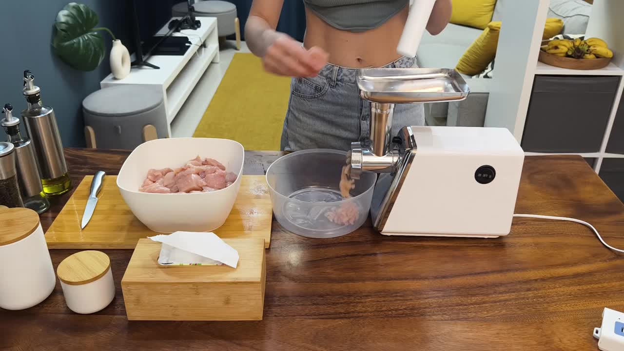 Donna che utilizza un tritacarne per preparare il cibo