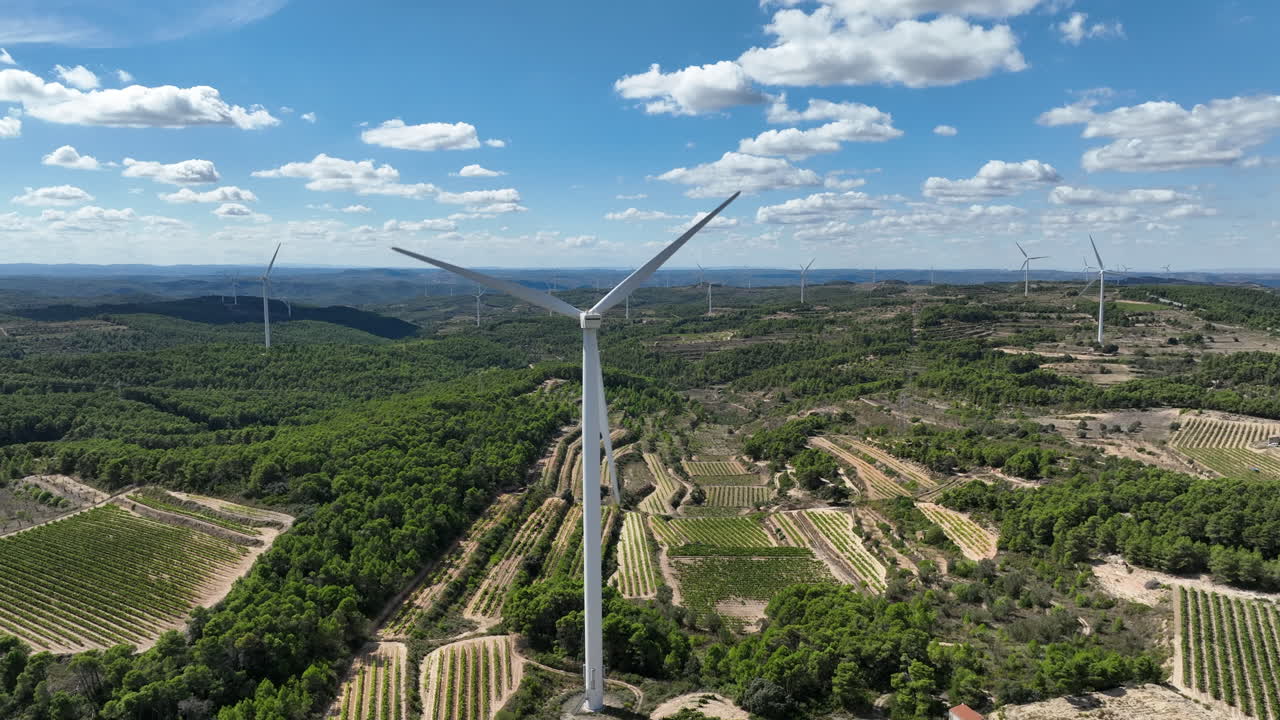cielo azul sobre turbina eólica giratoria en el parque de molinos de viento de coll de moro en cataluña, españa