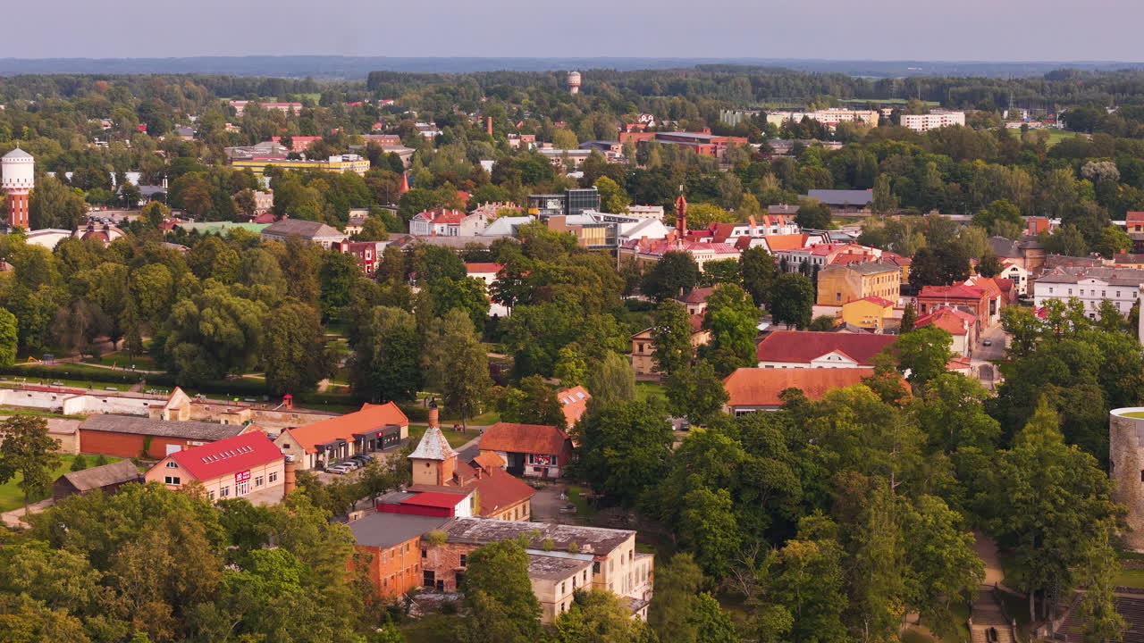 Scenic drone view of Cesis, Latvia, featuring historic buildings and lush greenery.