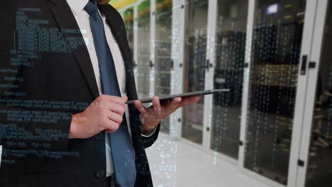 Man-using-digital-tablet-in-front-of-server-towers.