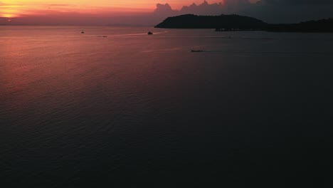 Imágenes-Aéreas,-órbita,-Panorámica,-Ascenso-De-Barcos-En-El-Océano-Antes-De-La-Costa-Tailandesa-En-Una-Hermosa-Puesta-De-Sol-Amarilla-Y-Roja