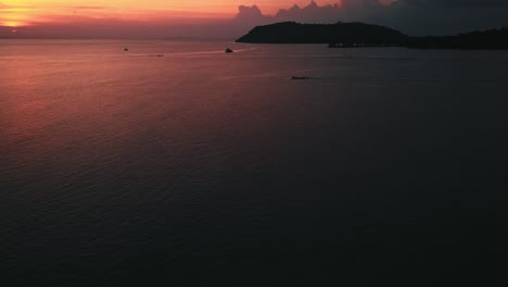 imágenes aéreas, órbita, pan, subida de barcos en el océano antes de la costa tailandesa en hermosa puesta de sol amarilla y roja