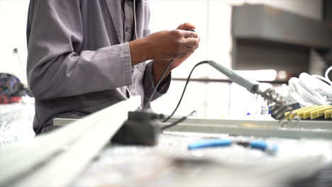 Person-sitting-at-table-working-with-hands-twinning-cable